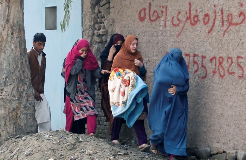 Afghan women leave the site of a blast and gun fire in Jalalabad. (photo credit: REUTERS/PARWIZ)