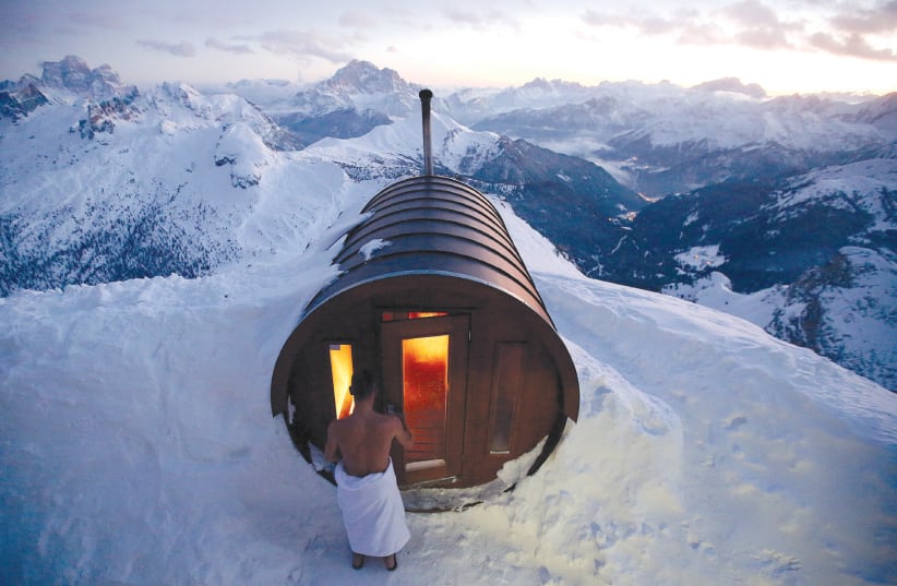 A MAN enters a sauna on the peak of Mount Lagazuoi in Cortina D’Ampezzo, Italy (photo credit: STEFANO RELLANDINI/REUTERS)