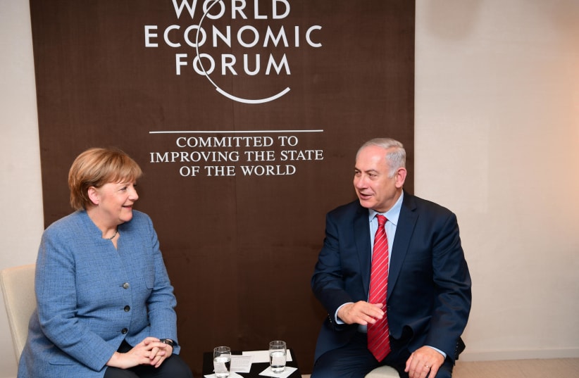 Prime Minister Benjamin Netanyahu and German Chancellor Angela Merkel meet at the World Economic Forum in Davos, Switzerland on January 24, 2018. (photo credit: AMOS BEN-GERSHOM/GPO)