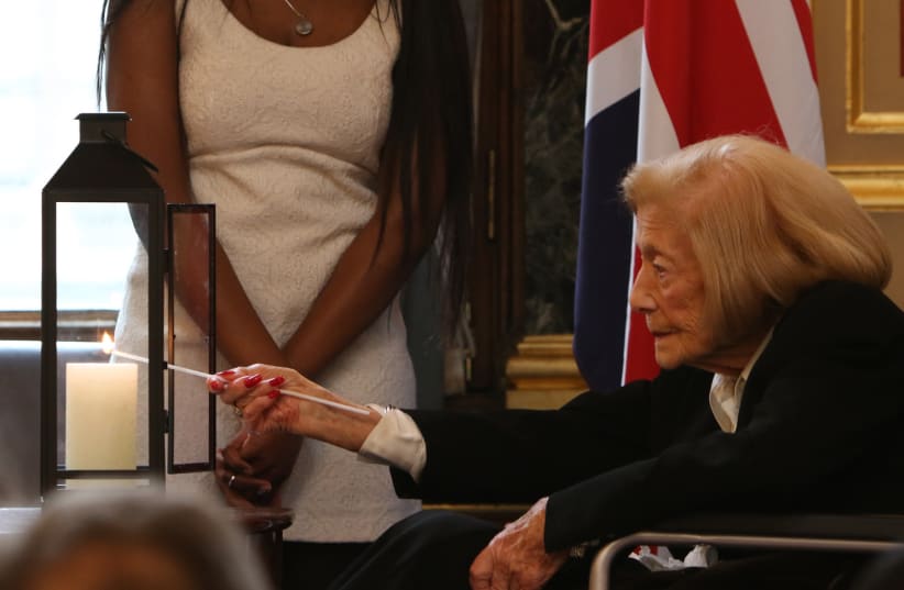 Holocaust survivor Gena Turgel MBE lights a candle at the British Foreign & Commonwealth Office's Holocaust Memorial Day event, 23 January 2018. (photo credit: FOREIGN & COMMONWEALTH OFFICE)