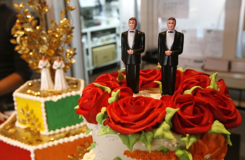 Bride and groom figurines are on display on wedding cakes at Cake and Art bakery in West Hollywood, California. (photo credit: REUTERS)