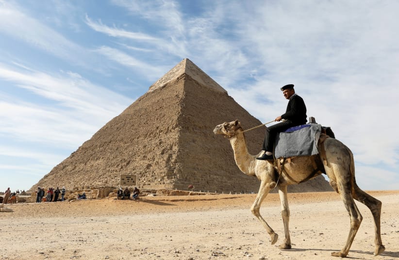 A police officer patrols the Giza Pyramids on his camel on the outskirts of Cairo, Egypt December (photo credit: MOHAMED ABD EL GHANY/REUTERS)