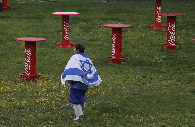 Man walks with Israeli flag in Berlin  (photo credit: REUTERS)