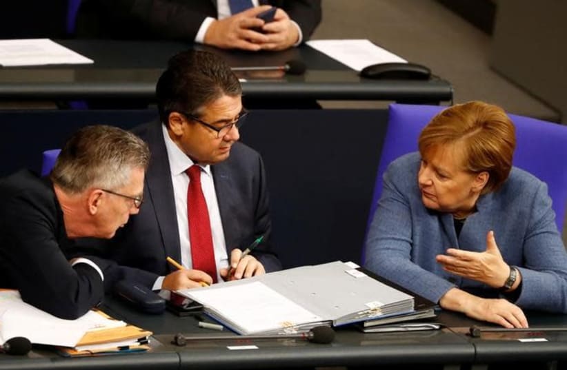 German Chancellor Angela Merkel, German Foreign Minister Sigmar Gabriel and German Interior Minister Thomas de Maiziere talk during a session of the lower house of parliament Bundestag in Berlin, Germany, December 12, 2017 (photo credit: REUTERS/FABRIZIO BENSCH)
