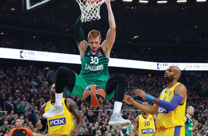 Maccabi Tel Aviv center Alex Tyus (right) looks on helplessly as Zalgiris Kaunas big man Aaron White (center) dunks for two of his eight points during a 99-84 defeat in Lithuania. (photo credit: UDI ZITIAT)