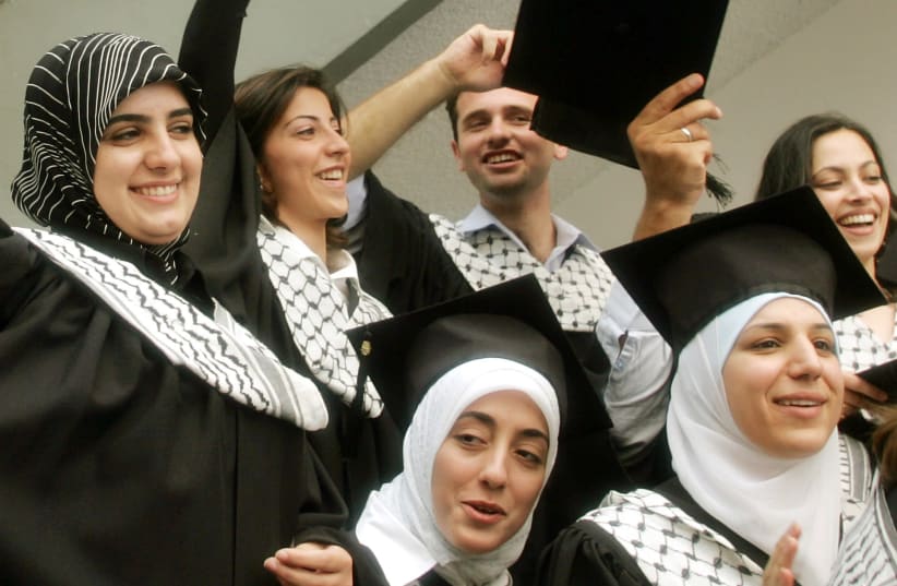 Palestinian students celebrate following a graduation ceremony at Al-Najah University in the West Bank city of Nablus. (photo credit: ABED OMAR QUSINI/REUTERS)