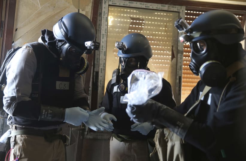UN chemical weapons experts inspect alleged chemical samples from an attack in Syria, 2013 (photo credit: STRINGER/ REUTERS)
