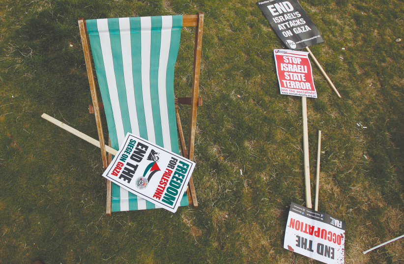 ANTI-ISRAEL SIGNS sit on a field after an anti-Israel rally in London (photo credit: REUTERS)