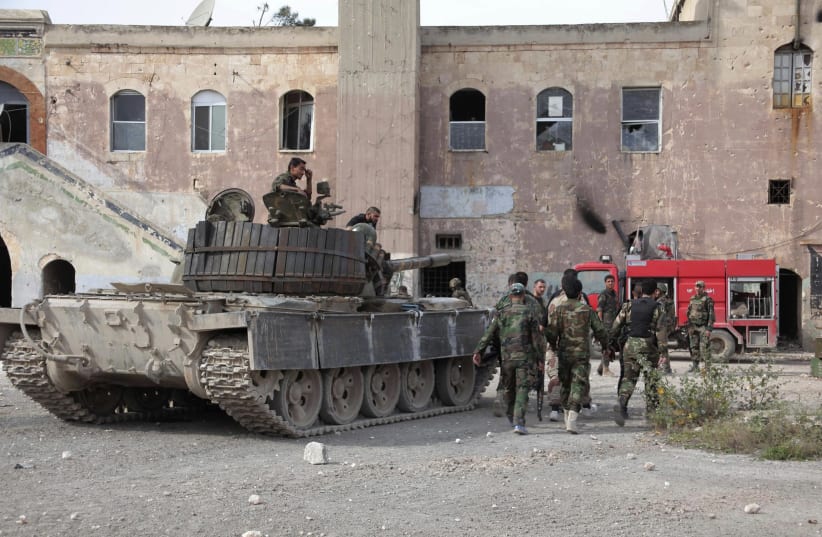 A SYRIAN regime tank and soldiers next to a building in central Syria (photo credit: REUTERS)