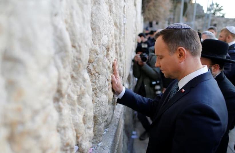 Polish President Andrzej Duda touches the Western Wall during a visit to the Old City of Jerusalem January 17, 2017 (photo credit: AMMAR AWAD/REUTERS)