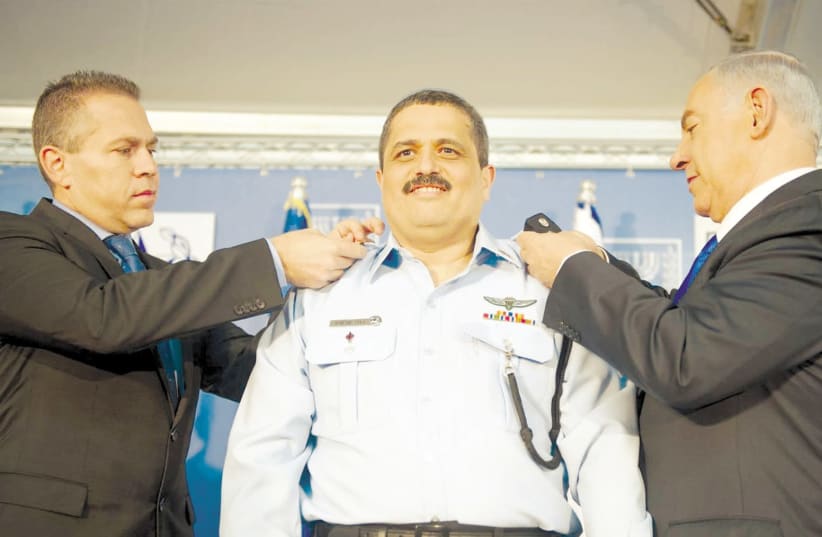 Prime Minister Benjamin Netanyahu pins the rank of police commissioner on Roni Alsheich with help from Public Security Minister Gilad Erdan in December 2015 (photo credit: COURTESY ISRAEL POLICE)