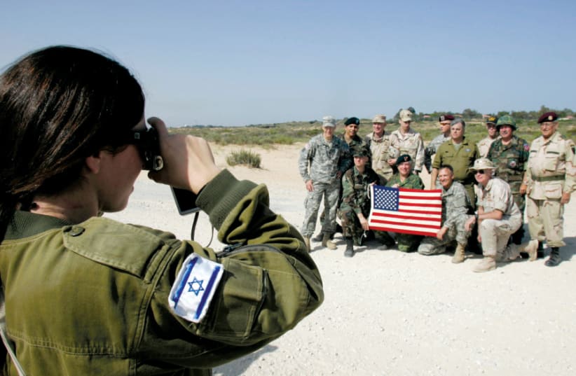 An Israeli soldier takes a photograph of paratroopers from around the world during a practice aerial jump at the Palmahim air force base in 2008 (photo credit: BAZ RATNER/REUTERS)
