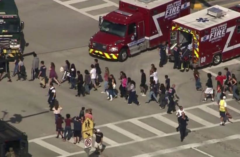 Students are evacuated from Marjory Stoneman Douglas High School during a shooting incident in Parkland, Florida, February 14  (photo credit: WSVN.COM VIA REUTERS)