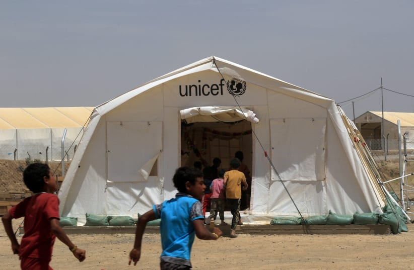 Displaced Iraqi boys enter a tent school set by United Nations Children's Fund (UNICEF) at Hammam al-Alil camp south of Mosul, Iraq (photo credit: ARI JALAL / REUTERS)