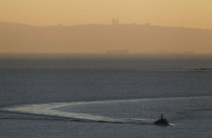 An Israeli naval vessel sails in the Mediterranean sea near the border with Lebanon, as Mount Carmel and the Israeli city of Haifa are seen in the background December 16, 2013 (photo credit: REUTERS/AMIR COHEN)