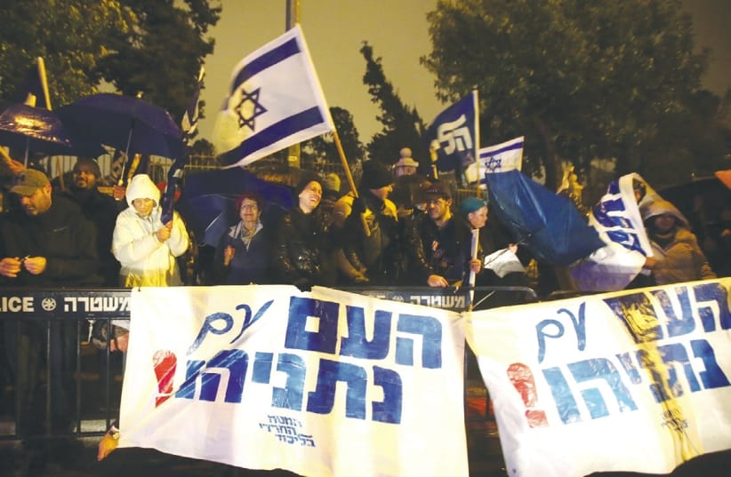 Protesters holding signs that say "The nation is with Netanyahu".  (photo credit: MARC ISRAEL SELLEM/THE JERUSALEM POST)