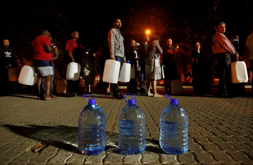People queue to collect water from a spring in the Newlands suburb as fears over the city's water crisis grow in Cape Town, South Africa (photo credit: REUTERS/MIKE HUTCHINGS)