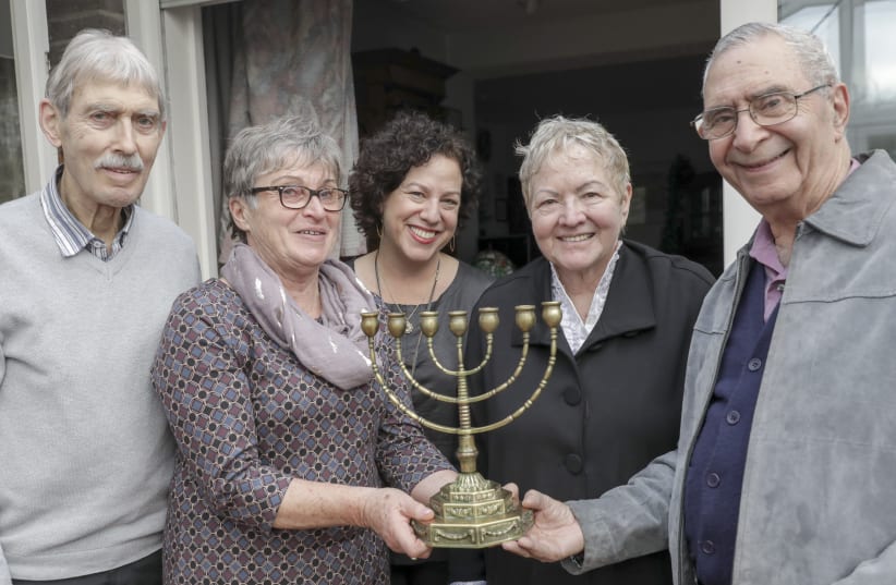 From left to right: Hubert Baumeister, Roswitha Baumeister, Yotvat Palter Dycian, Aviva Palter, Guri Palter hold the menorah at the home of Hubert and Roswitha Baumeister in Osnabrück on February 5th (photo credit: JÖRN MARTENS)