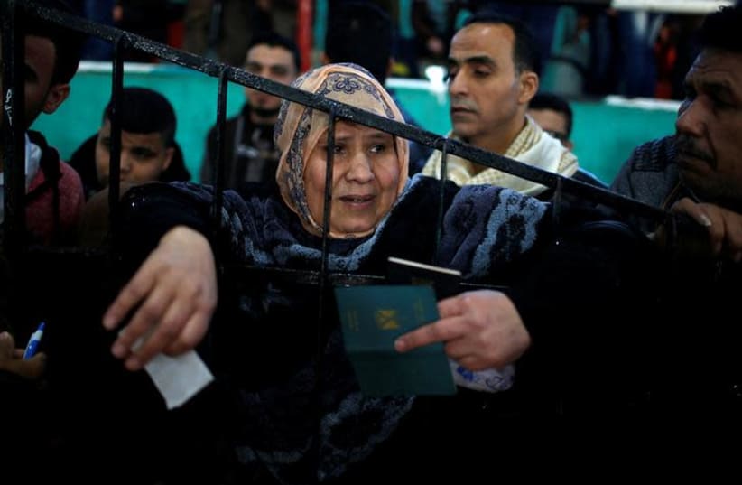 A woman waits for a travel permit to cross into Egypt through the Rafah border crossing after it was opened by Egyptian authorities for humanitarian cases, in the southern Gaza Strip February 21, 2018. REUTERS/Mohammed Salem (photo credit: REUTERS/MOHAMMED SALEM)
