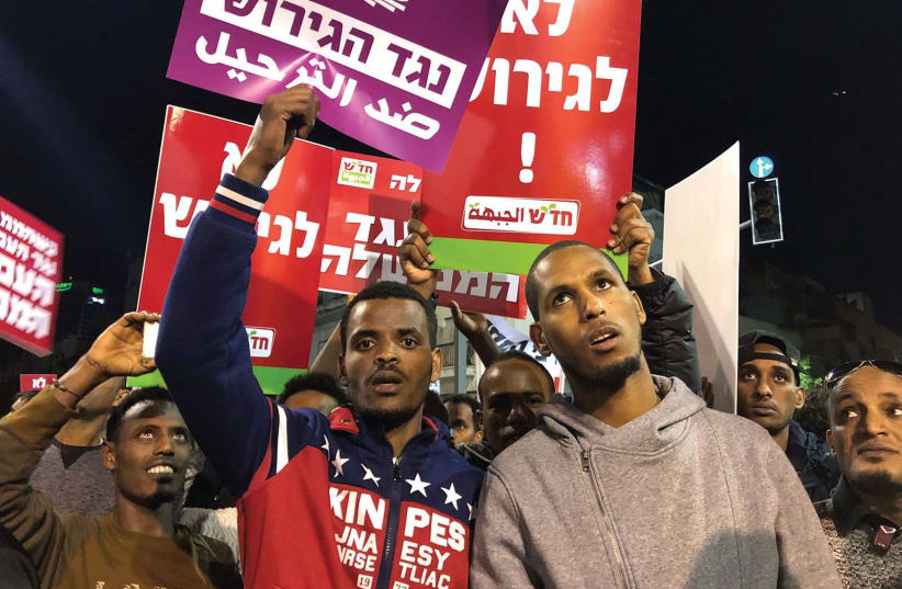 AFRICAN ASYLUM-SEEKERS hold signs during a protest against the Israeli government’s plan to deport part of their community. (photo credit: ANNA AHRONHEIM)