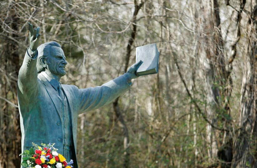  A Garland sits under a large bronze statue of evangelist Billy Graham on the grounds of a Christian conference center in Ridgecrest, North Carolina (photo credit: REUTERS)