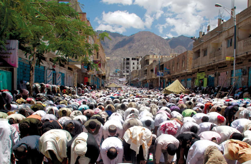 ANTI-GOVERNMENT protesters perform the Friday weekly prayers during a rally to demand the ouster of Yemen’s president Ali Abdullah Saleh in the southern city of Taiz in 2011 (photo credit: REUTERS/KHALED ABDULLAH)