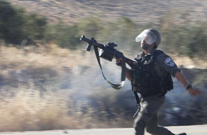 An Israeli border police officer runs during clashes with Palestinian protesters, August 8, 2015. (photo credit: REUTERS)