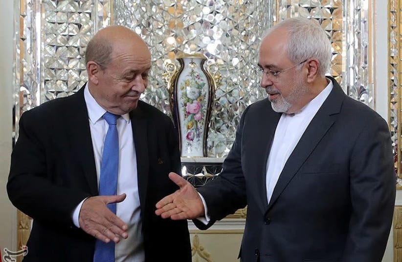 Iranian Foreign Minister Mohammad Javad Zarif reaches out to shake hands with French Foreign Affairs Minister Jean-Yves Le Drian in Tehran, Iran, March 5, 2018. (photo credit: REUTERS)