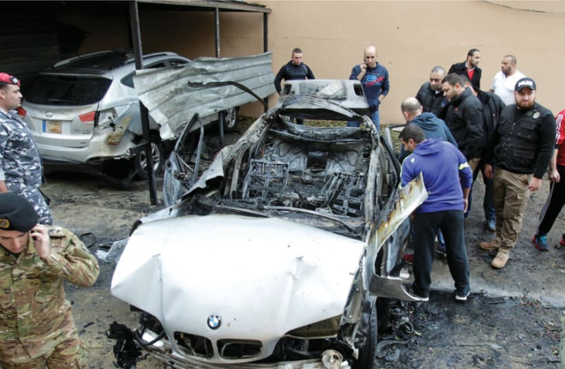 Security personnel inspect a damaged BMW in Sidon on January 14, after a reported assassination attempt on Mohamed Hamdan (photo credit: REUTERS)