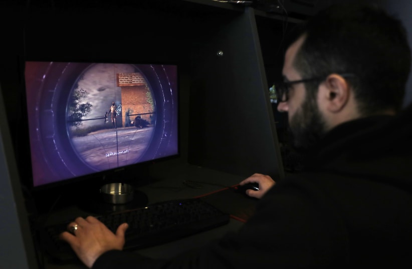 A Lebanese man plays a computer game created by Hezbollah called "Holy Defence" (photo credit: JOSEPH EID / AFP)