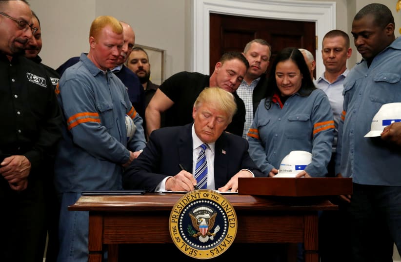 U.S. President Donald Trump signs a presidential proclamation placing tariffs on steel and aluminum imports at the White House in Washington, U.S. March 8, 2018. (photo credit: REUTERS/LEAH MILLIS)