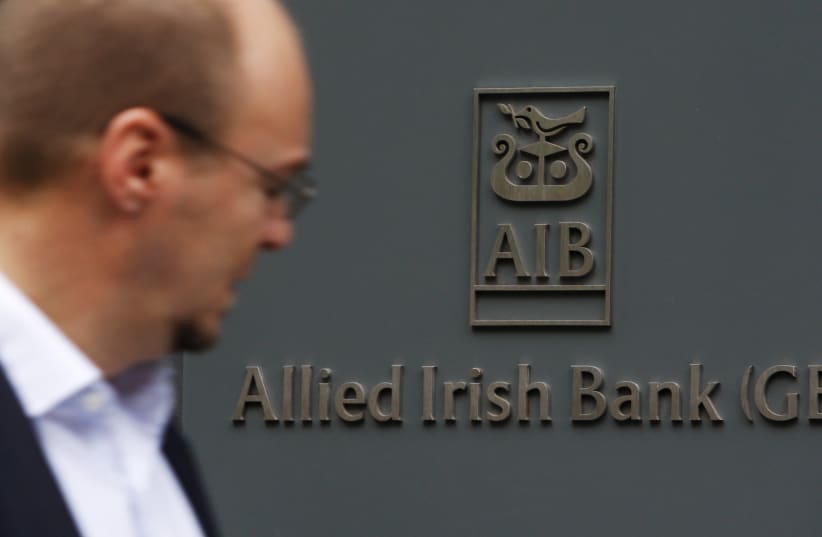 A pedestrian passes a branch of Allied Irish Bank in London (photo credit: REUTERS)