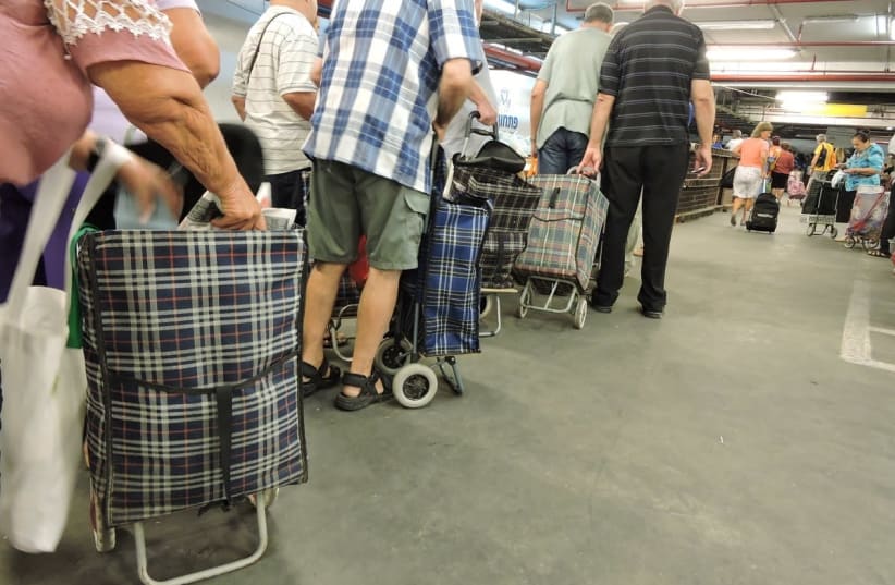 Needy people stand in line to buy food basket at the Pitchon Lev packaging and distribution center in Rishon LeZion (photo credit: YAKI ZIMERMAN)