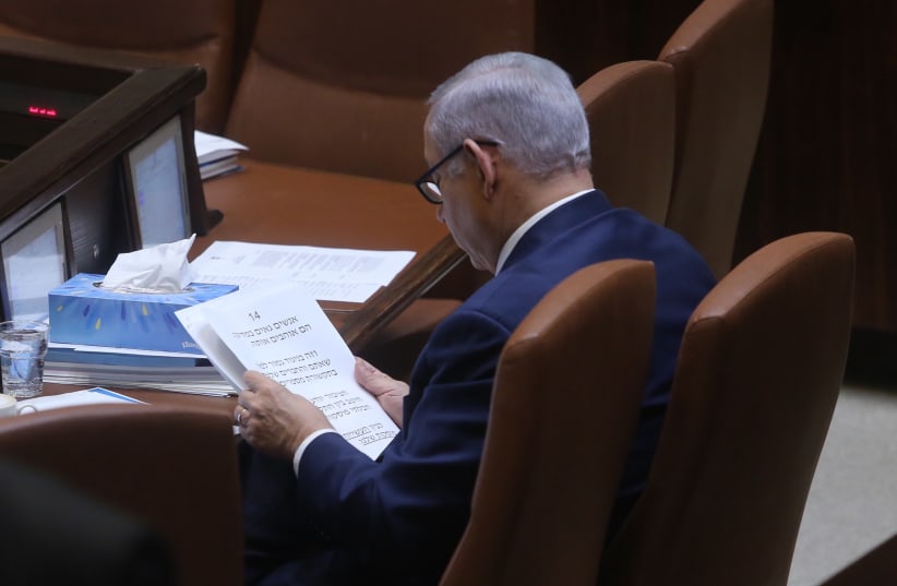 Prime Minister Benjamin Netanyahu reads from a speech in Knesset March 12, 2018. (photo credit: MARC ISRAEL SELLEM/THE JERUSALEM POST)
