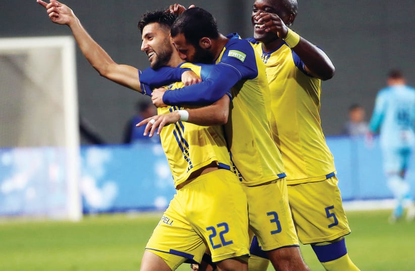 Maccabi Tel Aviv midfielder Avi Rikan (left) celebrates with teammates Yuval Spungin (center) and Jean-Sylvain Babin (right) (photo credit: UDI ZITIAT)