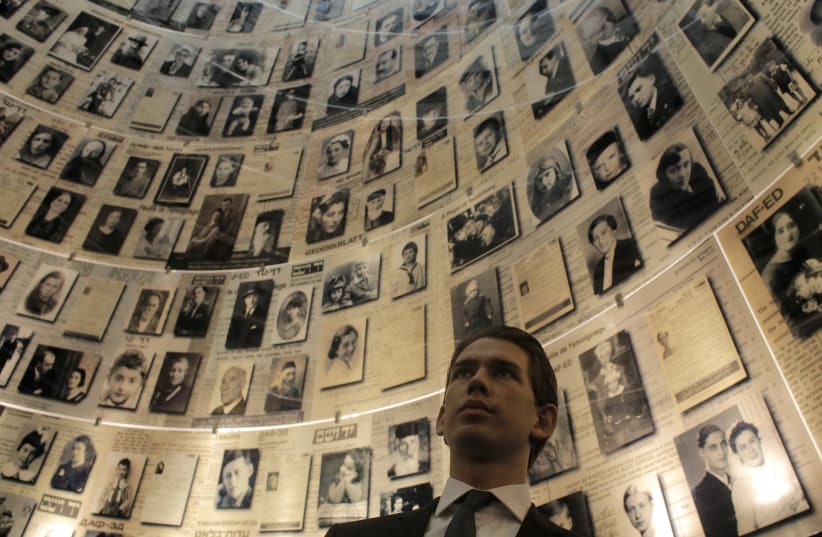 Austria's Foreign Minister Sebastian Kurz looks at pictures of Jews killed in the Holocaust during his visit to the Hall of Names at Yad Vashem's Holocaust History Museum in Jerusalem April 22, 2014 (photo credit: AMMAR AWAD / REUTERS)