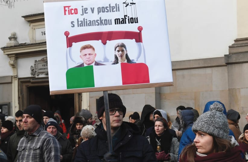Participants hold a banner reading: ‘PM Robert Fico in bed with Italian mafia’ during a march in honor of murdered Slovak investigative reporter Jan Kuciak and his girlfriend, Martina Kusnirova, in Bratislava, Slovakia, in February (photo credit: REUTERS)