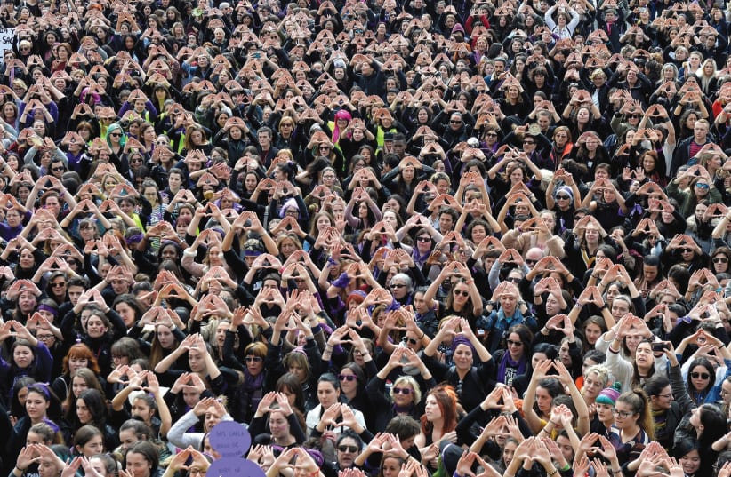 Protesters form triangles with their hands during a demonstration for women’s rights in Bilbao, Spain, on March 8, International Women’s Day (photo credit: REUTERS)