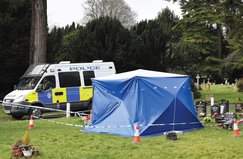 A police van is parked next to a tent covering the headstone of Alexander Skripal (photo credit: REUTERS)