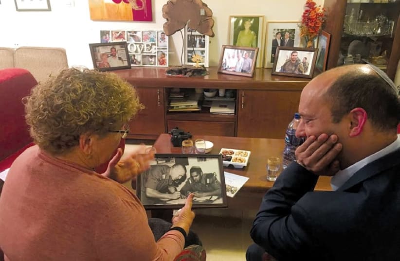 MIRIAM PERETZ shows a photo of her sons, who died in the service of the IDF, to Education Minister Naftali Bennett. (photo credit: Courtesy)