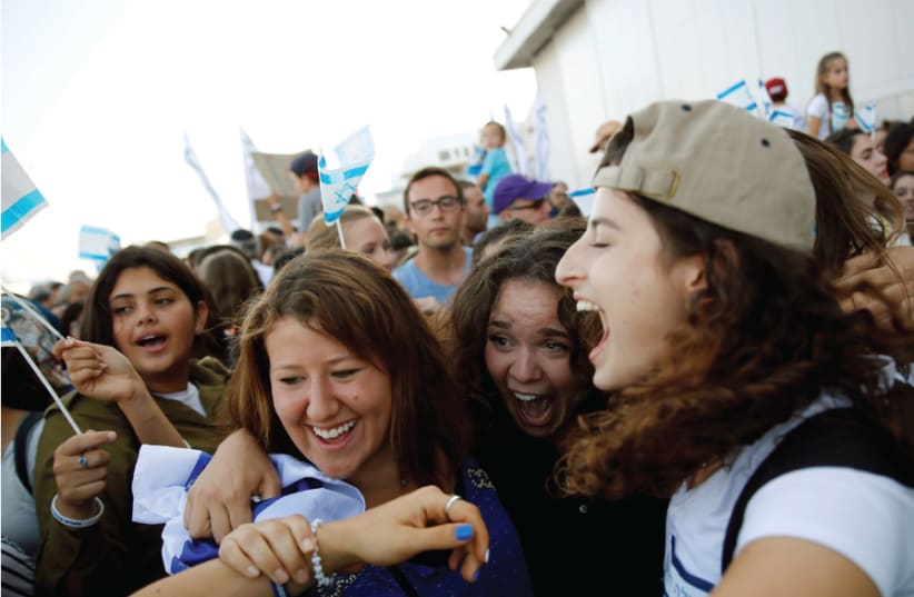 AN ‘OLAH HADASHA’ from North America (right) reacts as she is welcomed after landing at Ben-Gurion International Airport in 2016 (photo credit: BAZ RATNER/REUTERS)
