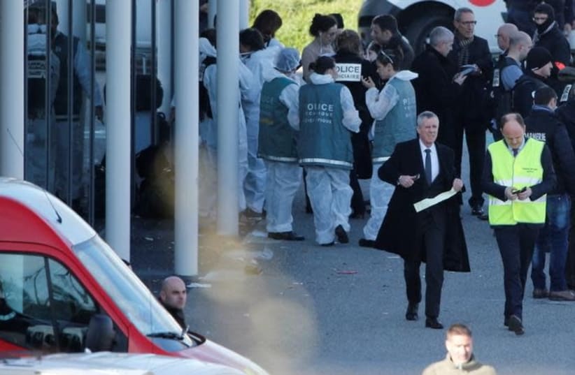 Paris prosecutor Francois Molins, Police officers and investigators are seen in front of a supermarket after a hostage situation in Trebes, France, March 23, 2018 (photo credit: REUTERS/JEAN-PAUL PELISSIER)