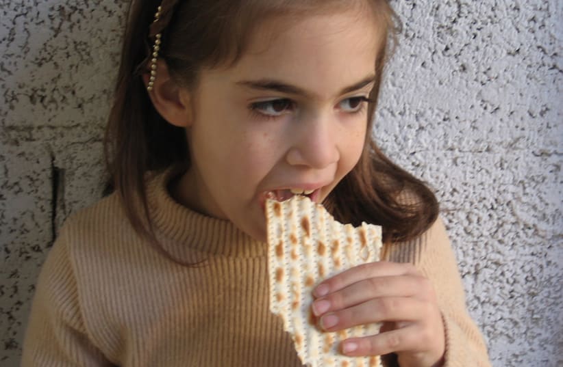 A girl eating matza (photo credit: YAD EZRA VESHULAMIT)