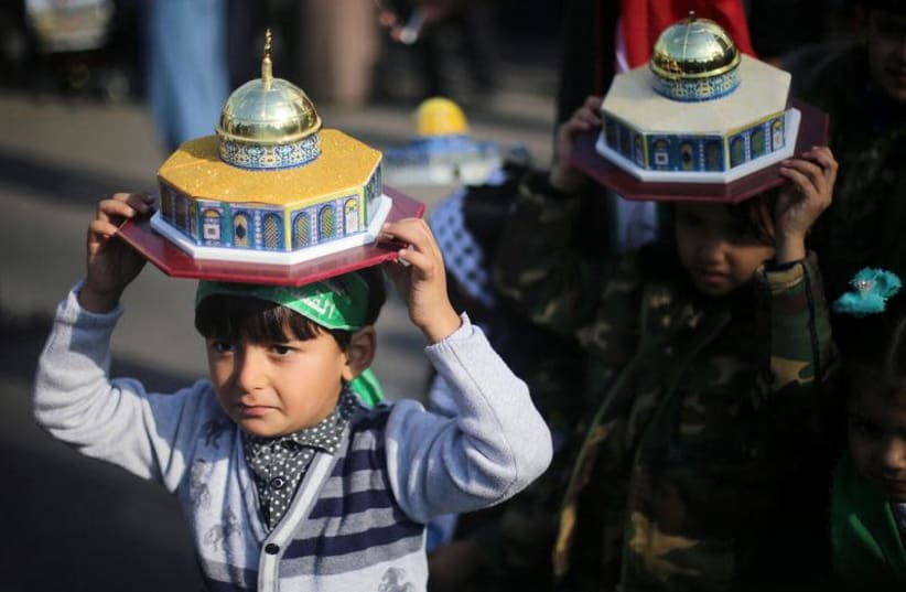 Palestinian children hold models depicting the Dome of the Rock during a protest against U.S. President Donald Trump's decision to recognize Jerusalem as the capital of Israel, near the central Gaza Strip December 15, 2017 (photo credit: IBRAHEEM ABU MUSTAFA / REUTERS)