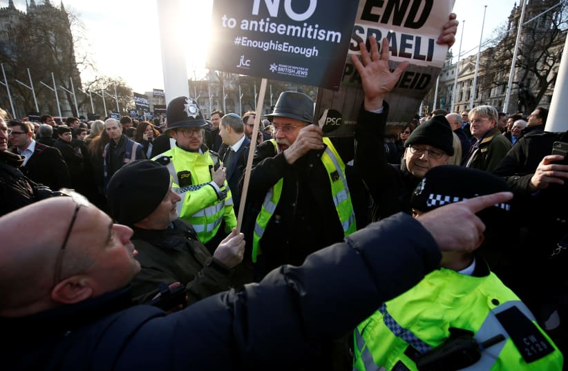 Protesters hold placards and flags during a demonstration opposing antisemitism, in Parliament Square in London, Britain, March 26, 2018.  (photo credit: REUTERS)