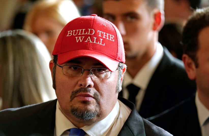 Virginia Republican party leader Fredy Burgos wearing a "Build the Wall" hat at an event to commemorate Hispanic Heritage Month hosted by US President Donald Trump at the White House in Washington (photo credit: KEVIN LAMARQUE/REUTERS)