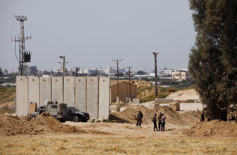 Israeli soldiers stand close to a security barrier near the border between Israel and the Gaza Strip, Israel March, 2018 (photo credit: AMIR COHEN/REUTERS)