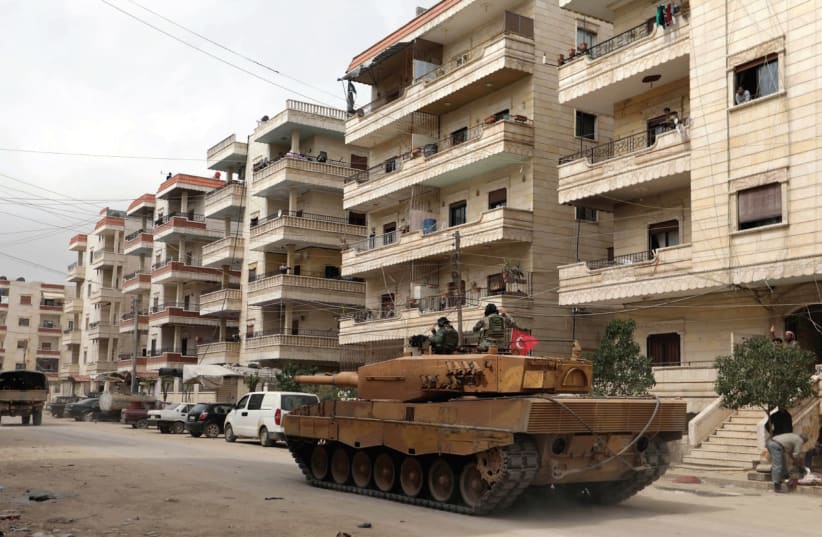 A Turkish tank rolls through the city of Afrin in northern Syria (photo credit: REUTERS)