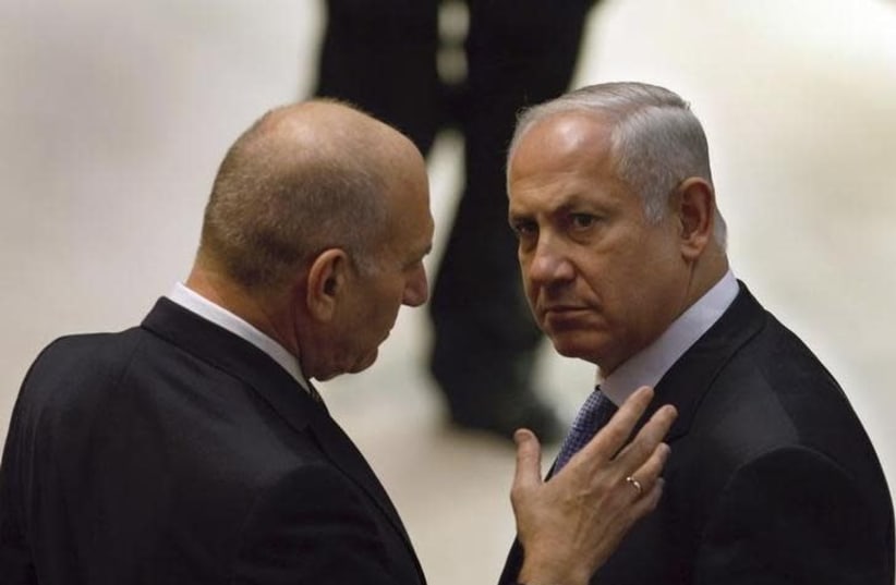 Incoming Israeli Prime Minister Benjamin Netanyahu (R) and outgoing Prime Minister Ehud Olmert speak on the plenum floor at the start of the swearing-in ceremony for Netanyahu's new government at parliament in Jerusalem March 31, 2009 (photo credit: DAVID SILVERMAN / REUTERS)