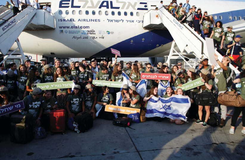 New immigrants from North America, including some 70 who will serve in the IDF, pose for a group picture upon landing in Israel on a special flight organized by Nefesh B’Nefesh (photo credit: BAZ RATNER/REUTERS)